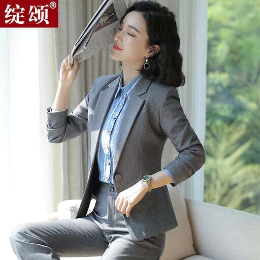 a woman in a suit and tie holding an umbrella.