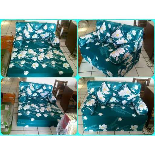 a bed with a blue sheet and a flower pattern.