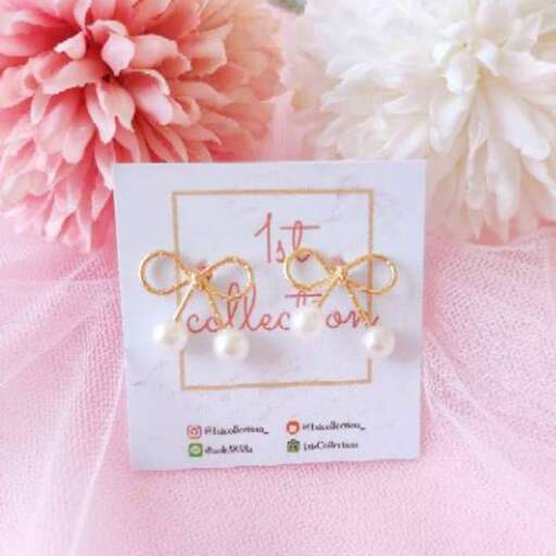a card with a gold letter and a white flower
