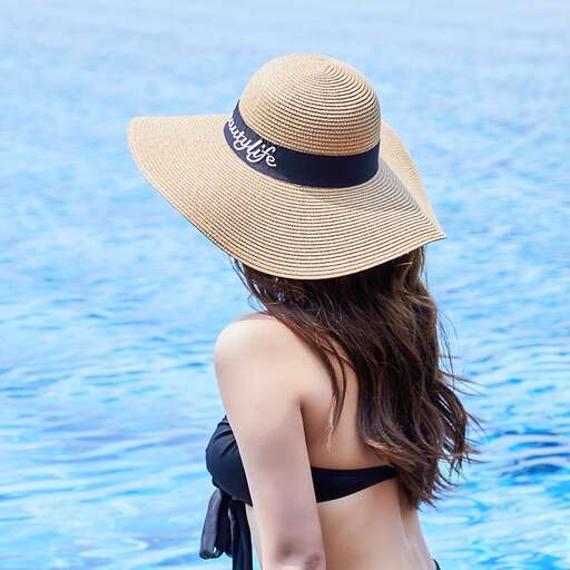 a woman in a black bikini and a hat in a pool.