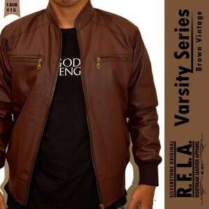 a man in a leather jacket standing next to a wall.