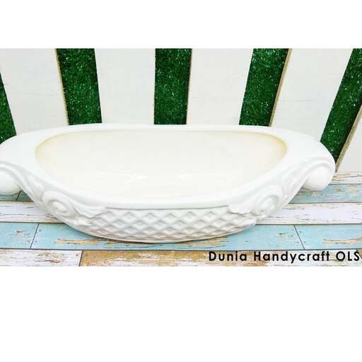 a white bath tub sitting on a wooden bench.