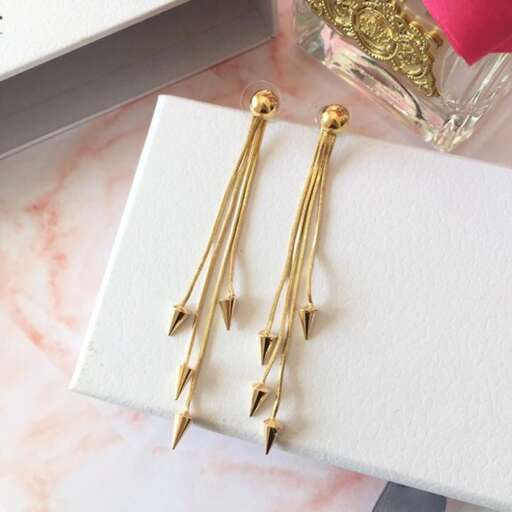 a pair of gold earrings with a pink rose.