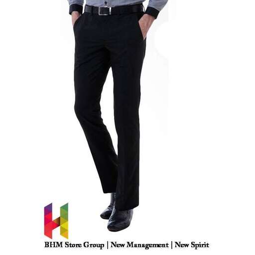 a man in a shirt and tie standing in a black suit.