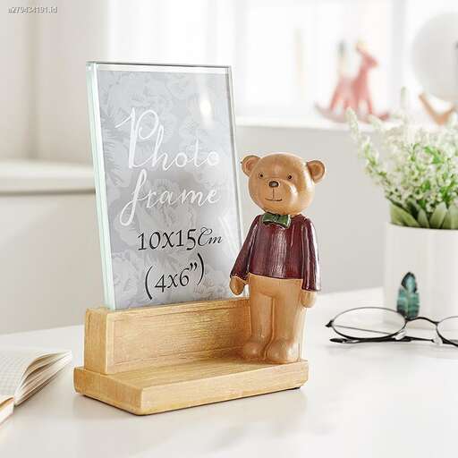a teddy bear figurine standing on a wooden stand.