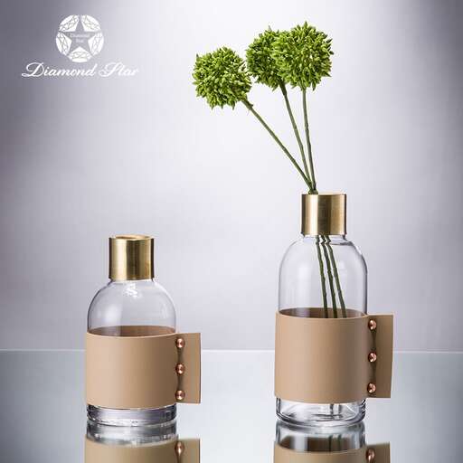 a bottle of perfume oil and flowers in a vase