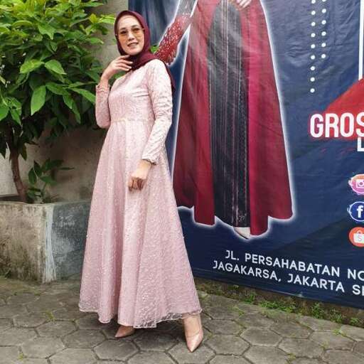 a woman poses for a picture in a pink dress.