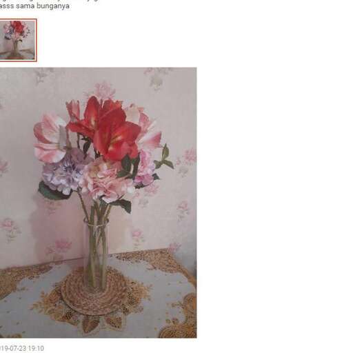 a vase of flowers on a table with a floral pattern.