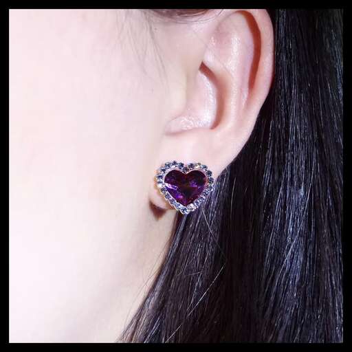 a pair of earrings with a large sapphire and diamond in the center.