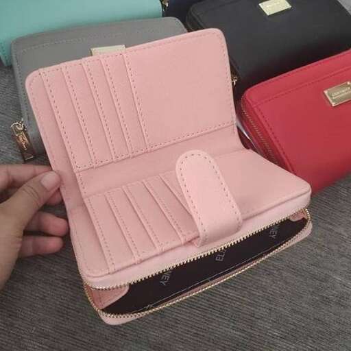 a person is holding a purse with a strap.