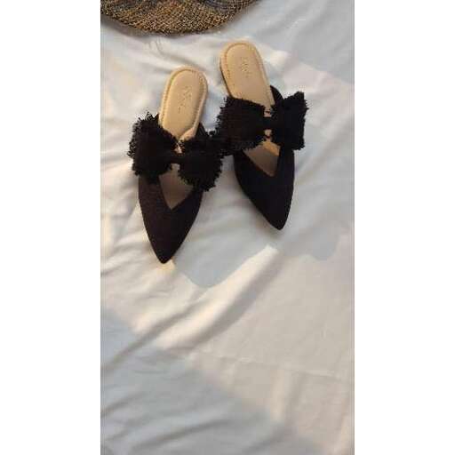 a pair of black suede shoes with a black fur trim.