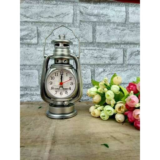 a clock sitting on a table next to a bouquet of flowers.