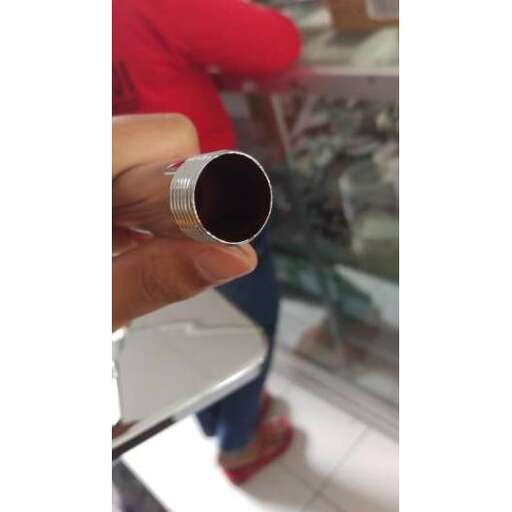 a person is holding a small metal device in front of a window.
