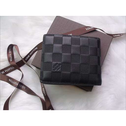 a black purse with a brown strap on a white surface.