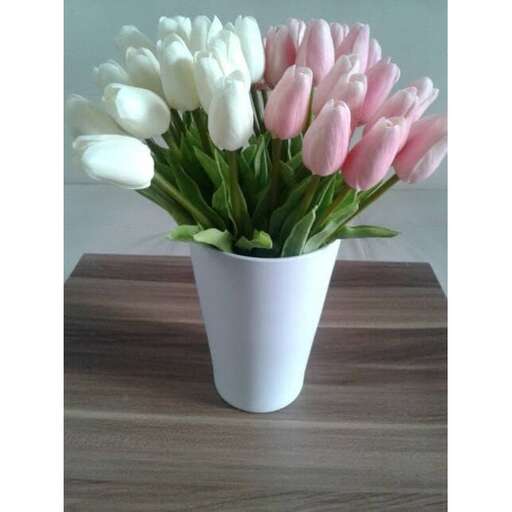 a white vase filled with pink and white flowers.