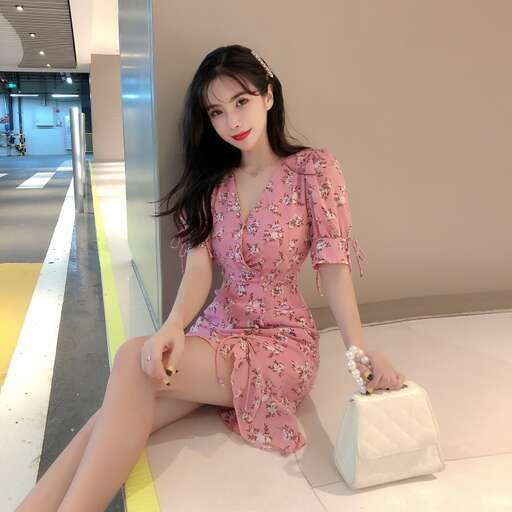 a model in a pink dress sitting on a bed