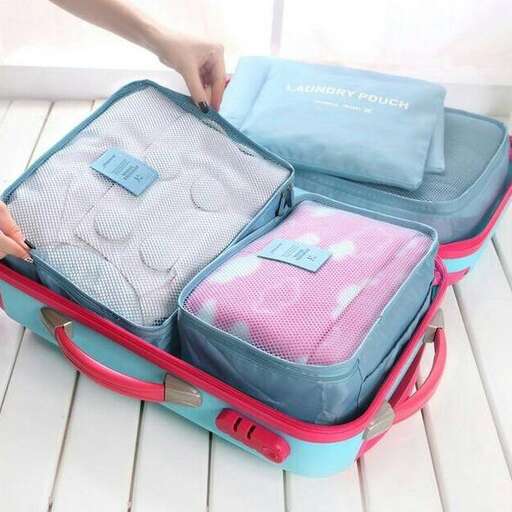 a person is putting their luggage into a suitcase.
