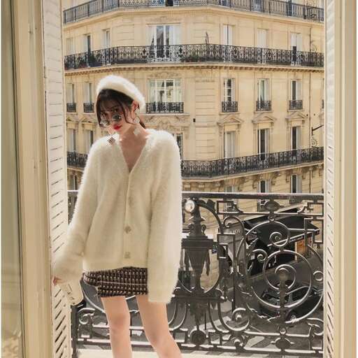 a girl in a white sweater and a black skirt standing on a balcony.