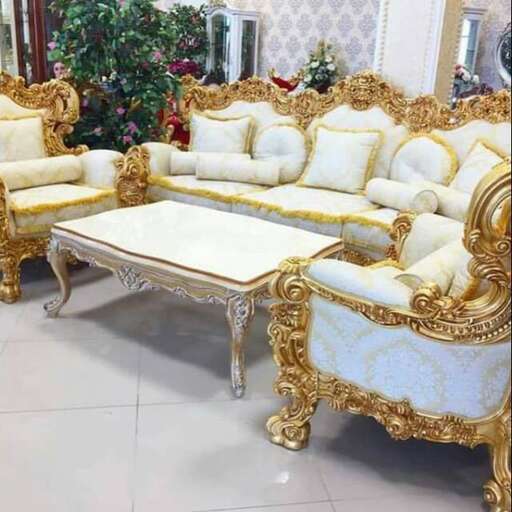 a gold and white couch and chairs in a room.