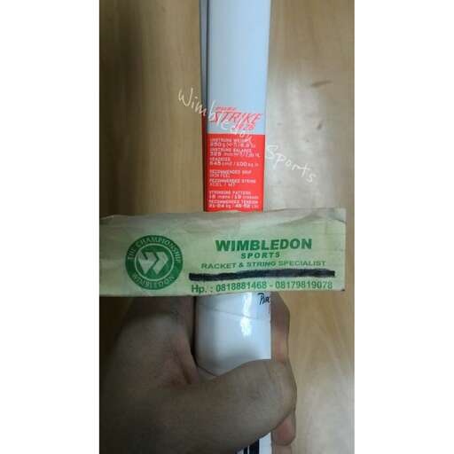 a person holding a tube of toothpaste on a table.