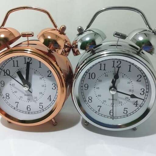 two clocks with different time zones on a white surface.