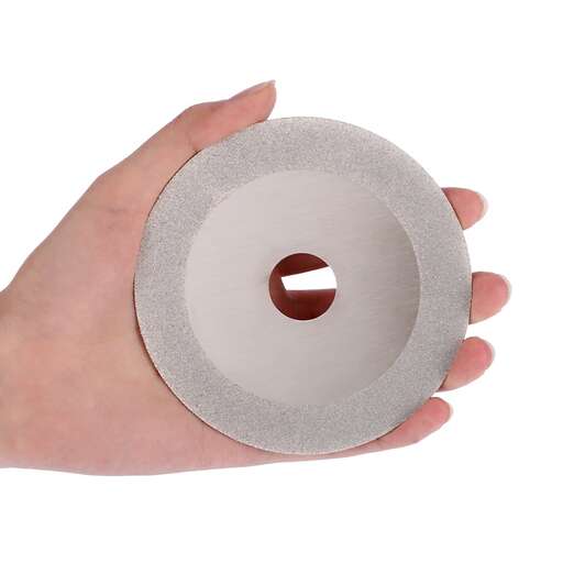 a hand holding a disc in a white background