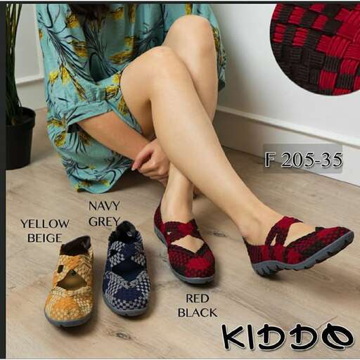 a woman sitting on a floor with a pair of shoes.