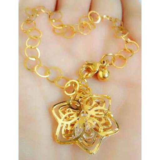 a gold pendant with a flower design