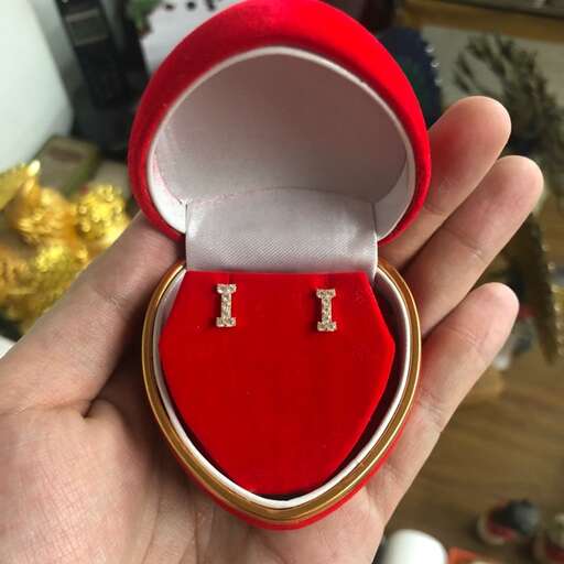 a hand holding a ring with gold and diamonds.