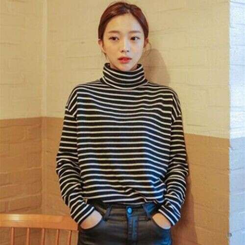 person is wearing a striped sweater and black pants