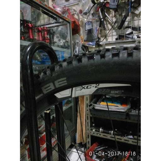 a bike wheel in a garage filled with lots of stuff.
