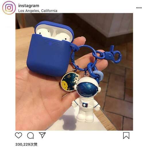 a hand holding a keychain with a pendant.