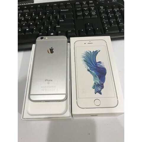 a white apple iphone sitting next to a keyboard.