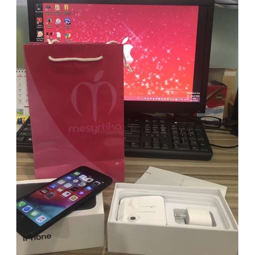 a new iphone and a bag on a desk.