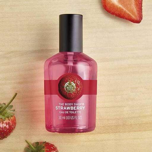a bottle of perfume with strawberries and strawberries