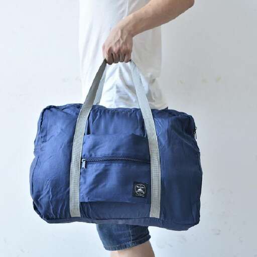 a man holding a blue bag with a strap.