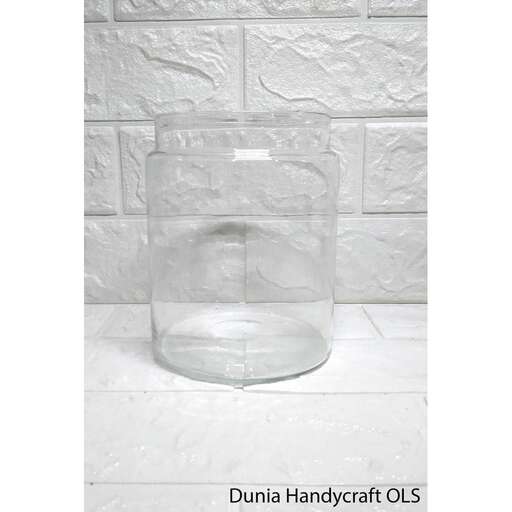 a glass vase on a white surface.