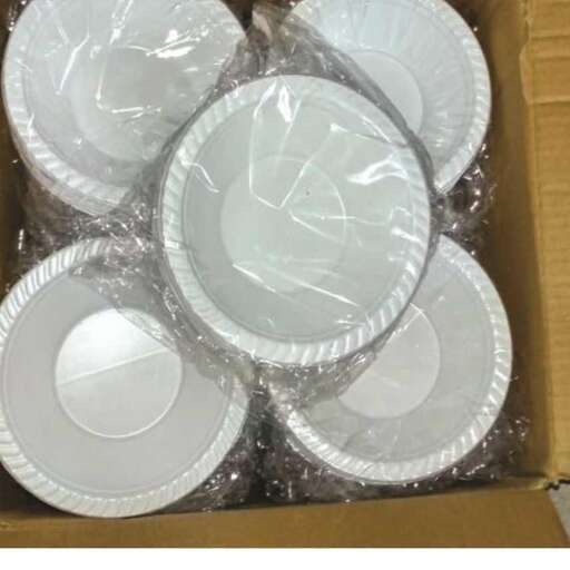 a box filled with white plates and plastic wrap.