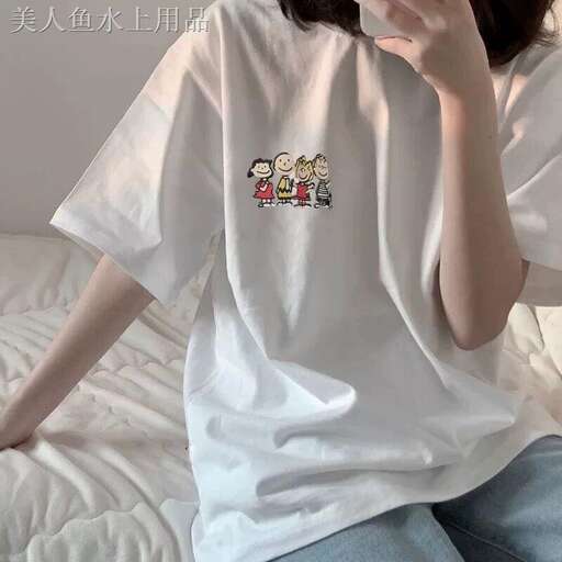 a woman sitting on a bed with a white shirt on.