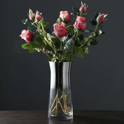 a vase filled with roses on top of a table.