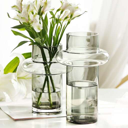 a vase with water and flowers on a table.