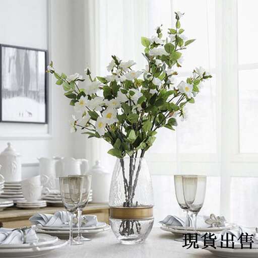 a vase of flowers sitting on a table next to a plate.
