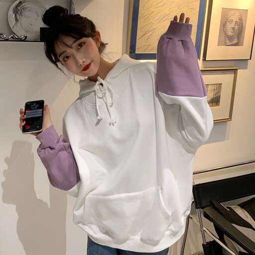 a woman wearing a white shirt and gloves holding a cell phone.