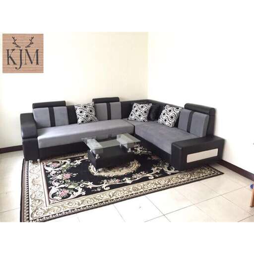 a living room with a black couch and a rug