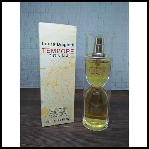 a bottle of perfume on a table with a bottle of perfume in the background.