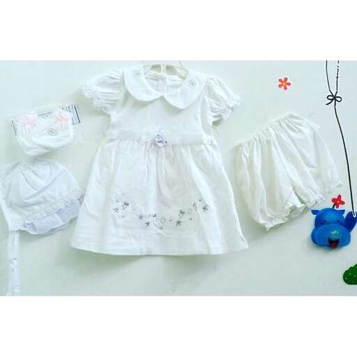 a white baby dress and a blue teddy bear.