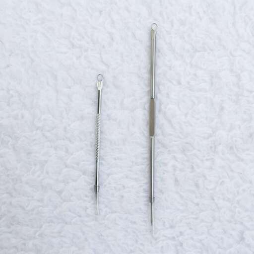 a pair of metal scissors on a white towel.