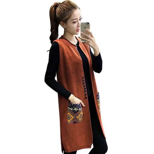 a woman in a long orange dress holding a cell phone.