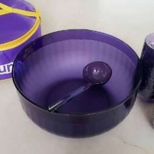 a purple bowl with a spoon inside of it.