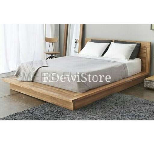 a bed with a wooden frame and a white pillow.